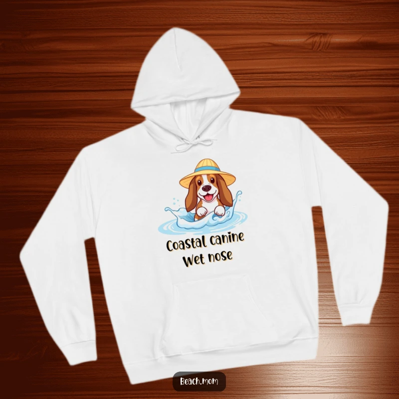 Funny Basset Hound hoodie showing a dog with a sun hat joyfully splashing in a tiny beach wave, perfect for cozy laughs.