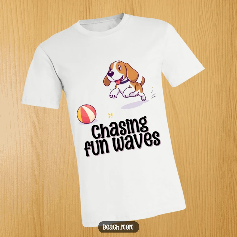 Funny Basset Hound t-shirt showing a dog gleefully chasing a large beach ball along the sandy shore, with a backdrop of the ocean.